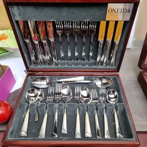 A large wooden cutlery canteen by Oneida Flatware. With thirty-eight cutlery pieces in a striking but simple linear design. Partial