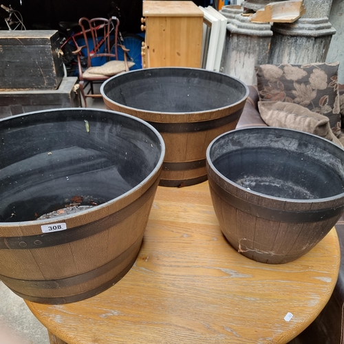 Three very large garden planters in the form of barrels.