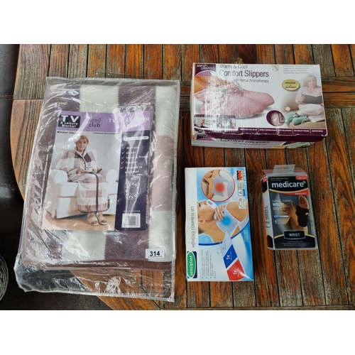 314 - A mixed lot of four items including a Zippable TV blanket, hot/cold compress set, a carpel tunnel wr... 