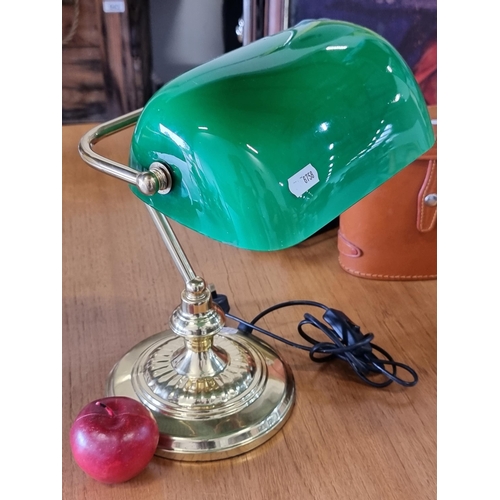 640 - A handsome brass bankers lamp with green glass tilting shade and three pronged plug. In very good co... 