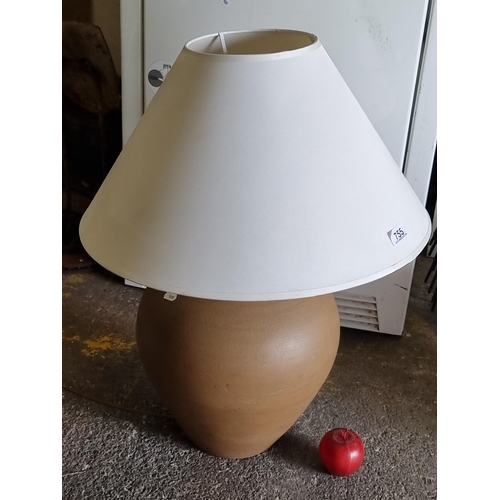 755 - A large terracotta table lamp with round base and circular cream shade.