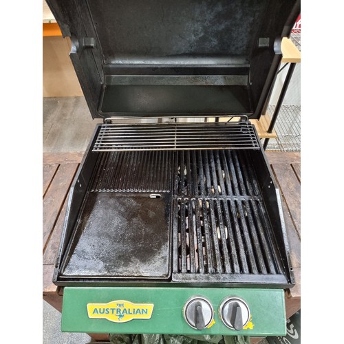 769 - An Australian gas-powered bbq grill with wooden frame and castors for easy movement. With a cylinder... 