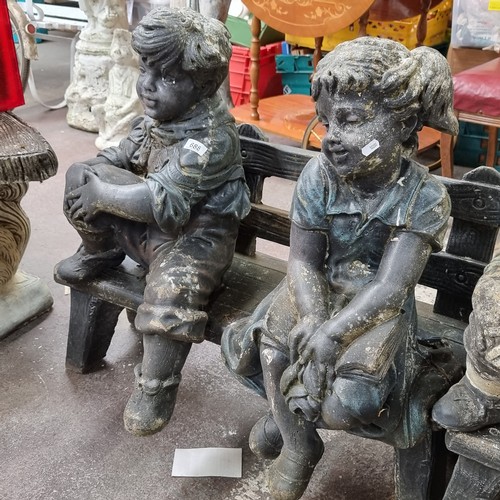 688 - A very heavy garden bench with two very heavy stone garden figures of a young boy and girl. Sweet ch... 