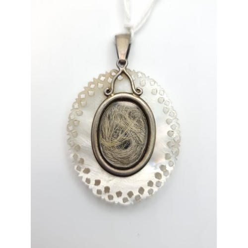 187 - A super Victorian mother of pearl hair locket. With very intricate detail and a lock of hair in the ... 