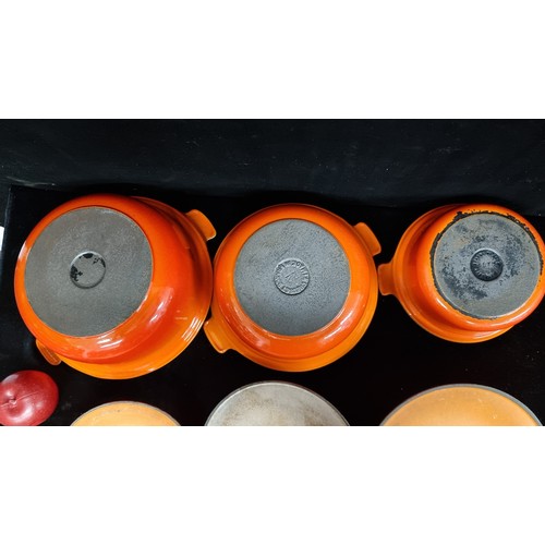 238 - A set of three Le Creuset cast iron graduating lidded dishes, finished in the brands iconic shade of... 