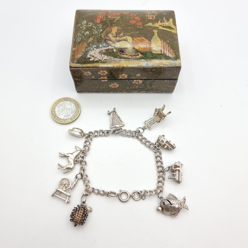 539 - A sterling silver charm bracelet, featuring an Irish spinning wheel, a rocking chair and an Irish ha... 