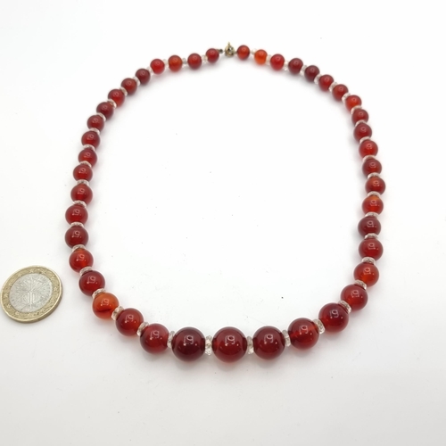 543 - A very good example of a vintage graduated Cornelian stone necklace, set with rock crystal spaces an... 