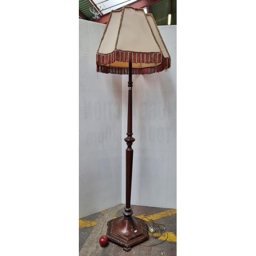 562 - A very tall vintage floor lamp with a turned stem and hexagonal base, finished with a super retro ta... 