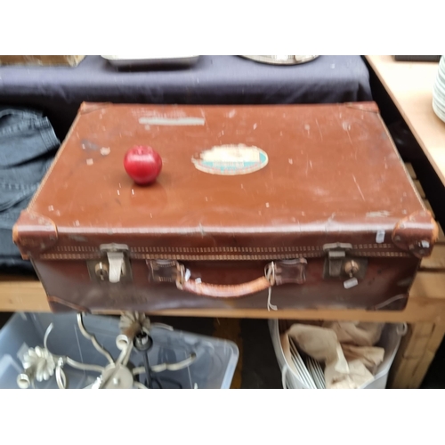 568 - A large antique leather suitcase with original label from the Canadian Pacific Cruises.