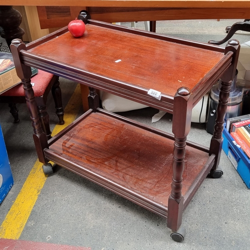 580 - A charming large wooden drinks trolley with turned wood detail, on casters.