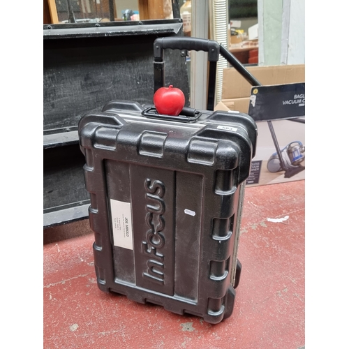 583 - An InFocus hard cover suitcase in black with combination lock, castors and additional handles for ca... 