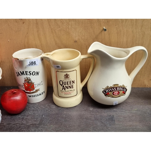 586 - Three branded ceramic jugs including a Jameson Whiskey Wade PDM example,  A Queen Anne Wade PDM exam... 