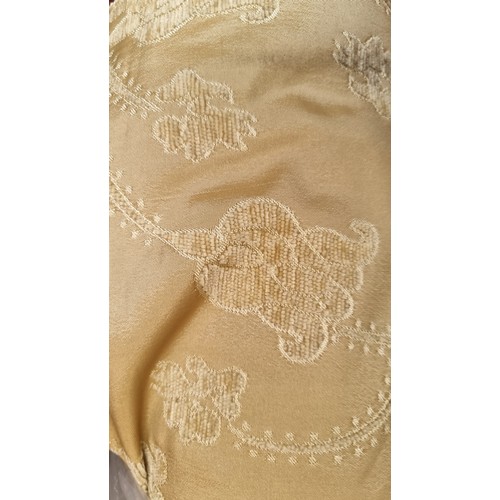 281 - A very large bolt of cream and gold fabric in a damask finish with floral motifs throughout.