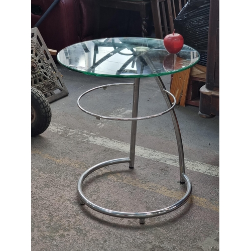 757 - A very modern two tiered designer metal and glass side table in the style of Eileen Gray.