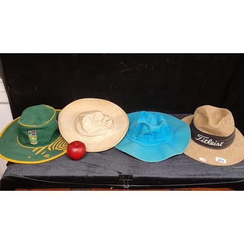 211 - A collection of four cricket hats including a South African World Cup 2003 and a Titleist straw hat.