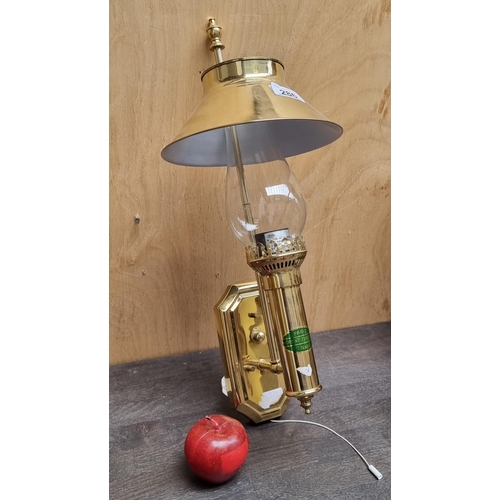 286 - A very cool wall mounting light fitting in the form of an oil lamp with brass body and shade on top.