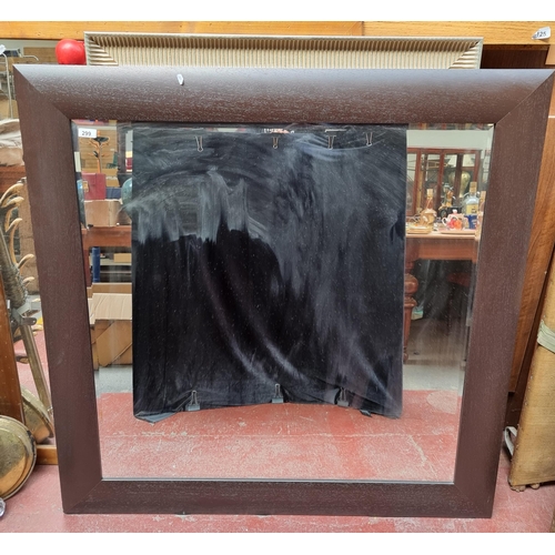 299 - A very large, bevelled mounted mirror, in a square chocolate brown frame H124cm x L124cm.