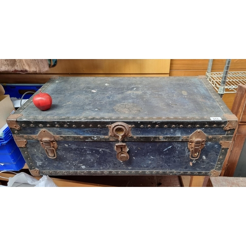 313 - A large antique hard travel case with metal clasps, studded supports and rope handles giving lovely ... 