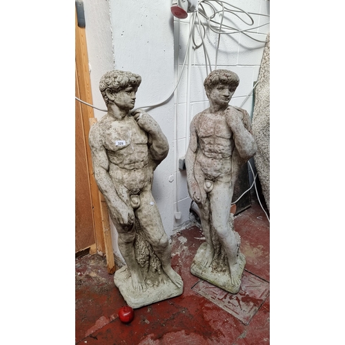 329 - Star Lot : A pair of tall heavy reconstituted stone garden statues, inspired by the Statue of David ... 