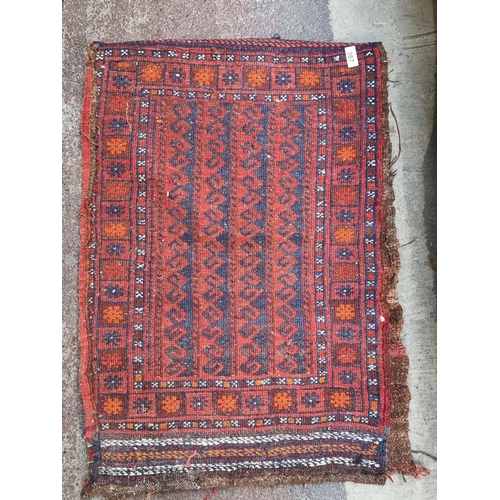 387 - An unusual vintage hand knotted Persian rug. In shades of red, blue and orange. With a protective ru... 