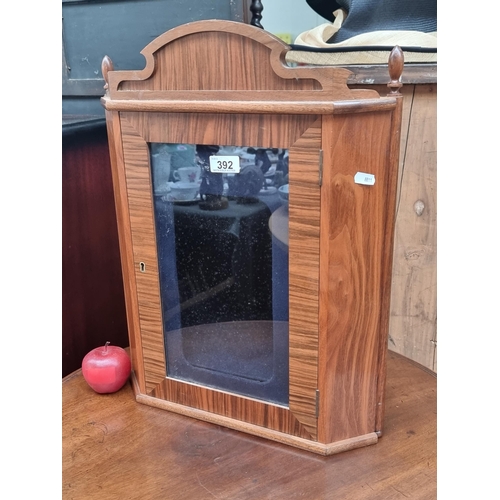 392 - A corner display cabinet with light fixture on interior and delicate turned wood finials. Locked. An... 