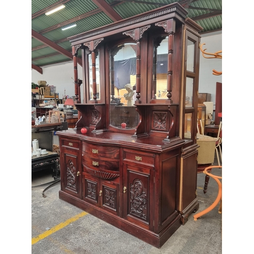 441 - A large V intorian sideboard with tall mirrored top, detail foliate carving to the four cupboard doo... 