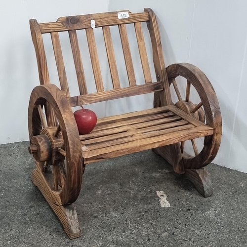 448 - A charming, neat sized children's seat. Handcrafted from wood with large wheel armrests.