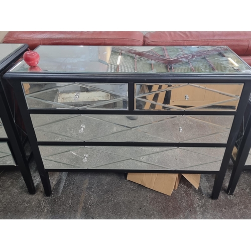 468 - A large mirrored chest of five drawers with geometric design to drawers and crystal handles, on a ma... 