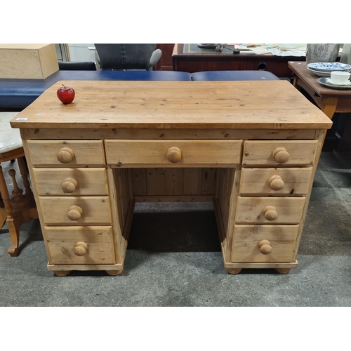 484 - A good sized solid pine knee hole desk with nine drawers for storage. Very nice example.