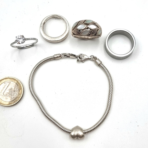 560 - A collection of four rings, three sterling silver (stamped 925) together with one stainless steel ri... 