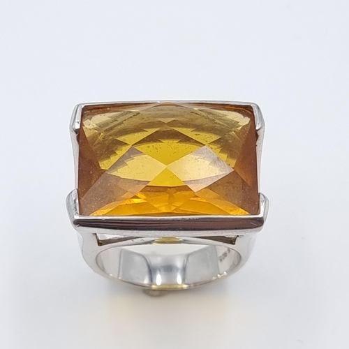 58 - An impressive facet cut Amber ring, set in thick sterling silver. Size: T. Weight: 18.92 grams.