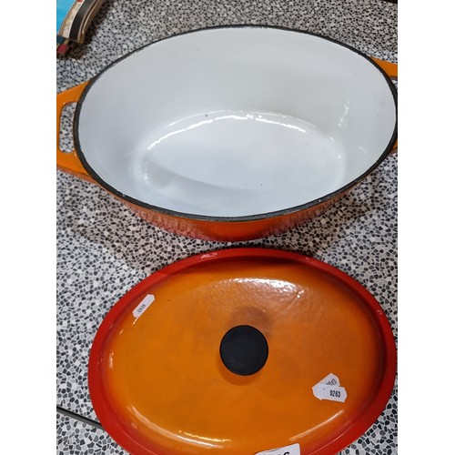 426 - A very heavy large cast iron casserole dish with heatproof handle. Dish is finished with an attracti... 