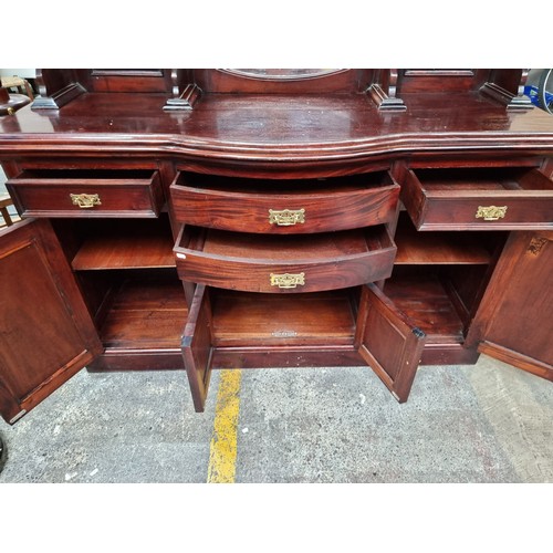 441 - A large V intorian sideboard with tall mirrored top, detail foliate carving to the four cupboard doo... 