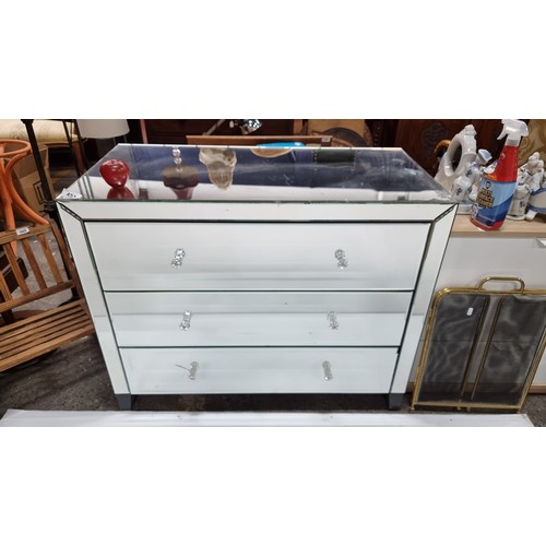 451 - A contemporary mirrored chest of drawers with three drawers, bevelled edges and glass handles. In go... 