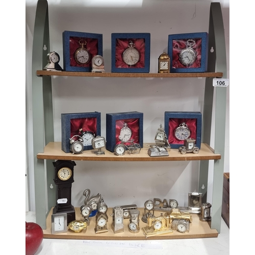 106 - A large collection of thirty-one miniature desk clocks and pocket watches on a 3 tier stand.