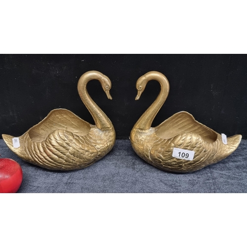 109 - A pair of heavy brass swan Jardinières with hollow backs ideal for placement of plant pots. Circa 19... 