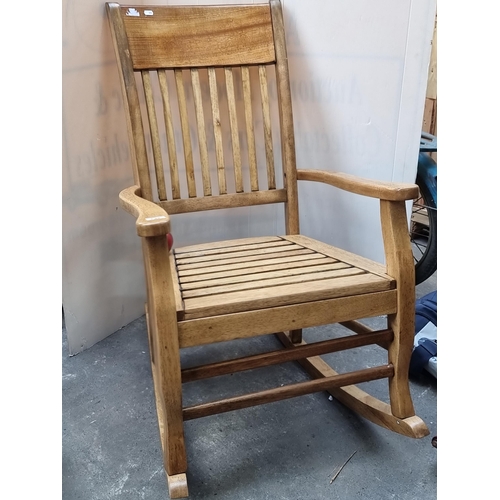 732 - A wonderful very rustic wooden rocking chair with slatted back and high curved arms. In good order.