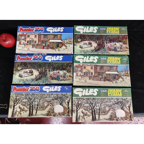 147 - A selection of six vintage jigsaw puzzles, circa the 1970s. Featuring illustrations by artist Giles.... 