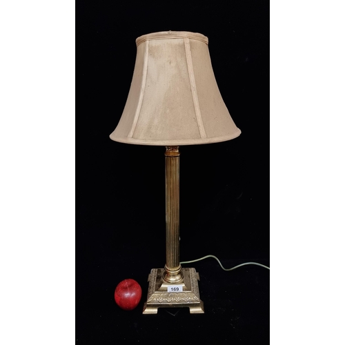 169 - An elegant table lamp with heavy brass base and reeded stem. Topped with a gold  shade.