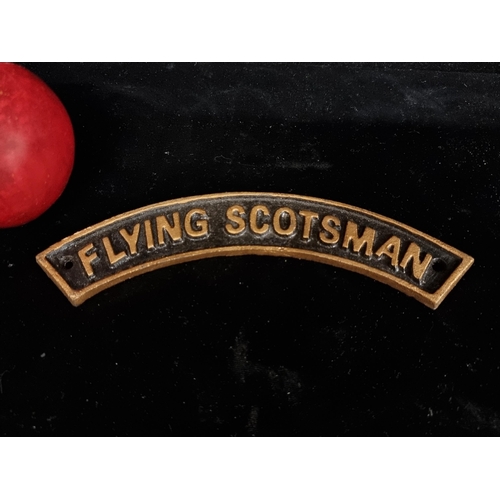 173 - A heavy cast Flying Scotsman wall mounting sign. With gilt lettering on a black background.