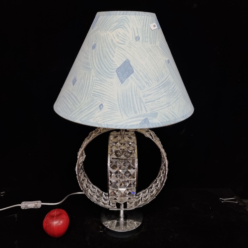 185 - A striking, double helix diamanté table lamp. With a pale blue lampshade.