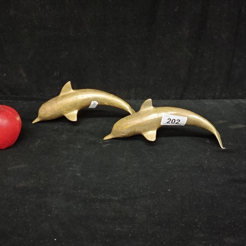 202 - A pair of solid brass leaping dolphins.