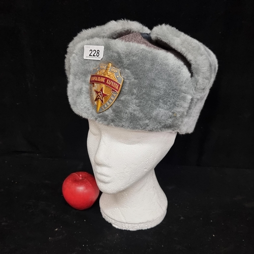 228 - A grey Russian Ushanka hat, with enamel communist badge to centre.