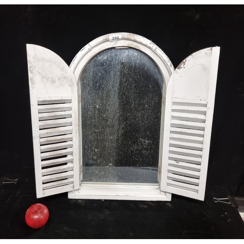 232 - A charming garden  wall mirror set into a wooden frame with opening shutters and a white distressed ... 