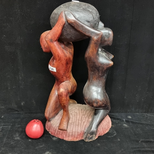 236 - A large vintage  figural wood sculpture, depicting male and female figures sharing a heavy load. In ... 