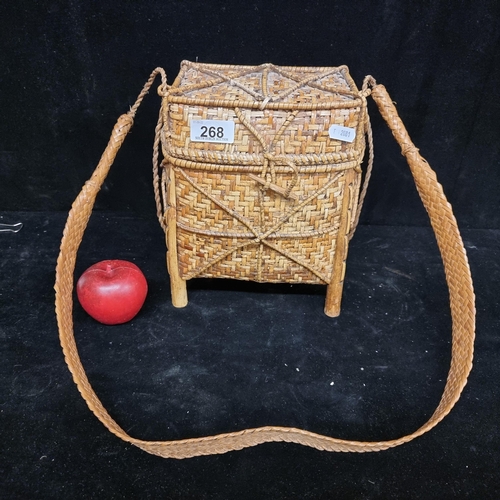 268 - A delightful vintage Chinese woven wicker footed storage basket with long handle and toggle fastenin... 