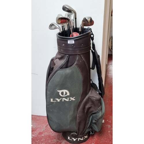 284 - A Lynx made golf bag with a number of clubs inside including Callaway Big Bertha 4 iron, and Callowa... 