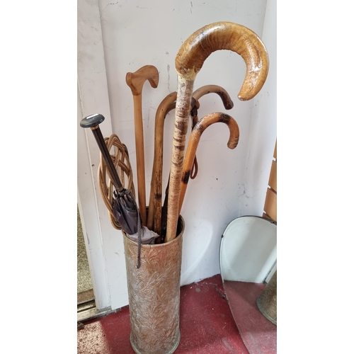 287 - A very nice, hammered brass umbrella stand filled with a good collection of six walking sticks, incl... 