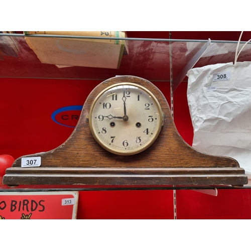 307 - An eight day mantle clock in a Napoleon hat case. Original convex glass face and brass bezel.