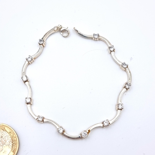 24 - A beautiful twist design sterling silver tennis bracelet, set with thirteen bright Moissanite gemsto... 